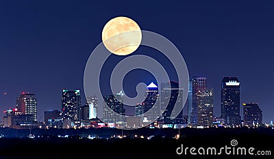 Night view of Tampa Florida skyline with huge full moon over buildings Stock Photo