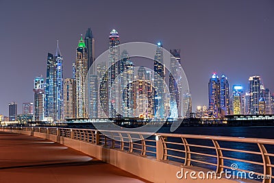 Night view to Dubai iconic skuscrappers panorama. Amazing illumination of the buildings reflected in the Gulf Editorial Stock Photo