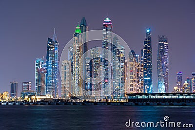 Night view to Dubai iconic skuscrappers panorama. Amazing illumination of the buildings reflected in the Gulf Editorial Stock Photo