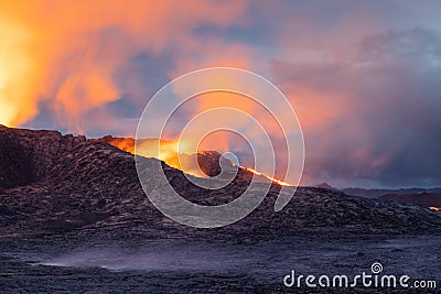 Night volcanic eruption. Fresh hot lava, flames and poisonous gases going out from the crater Stock Photo