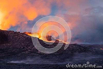 Night volcanic eruption. Fresh hot lava, flames and poisonous gases going out from the crater Stock Photo