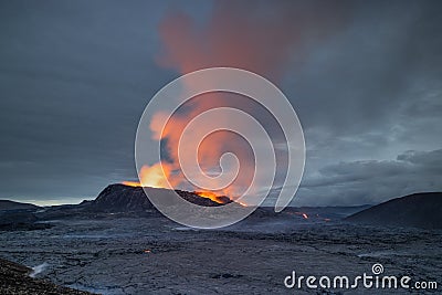 Night volcanic eruption. Fresh hot lava, flames and poisonous gases going out from the crater Stock Photo