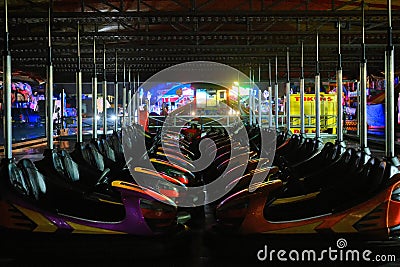 Nighttime view of two colourful rows of Dodgems facing each other. Stock Photo