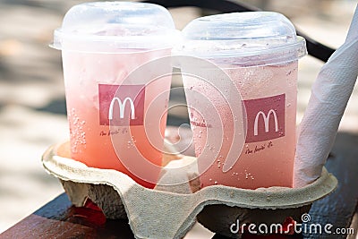 Nikolaev, Ukraine, August 5, 2019: McDonald`s lemonade in paper holder on a bench Editorial Stock Photo