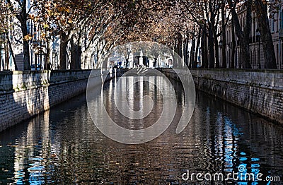 Nimes, Occitanie, France - Autumn trees reflecting in the canal of the Fountain gardens Editorial Stock Photo