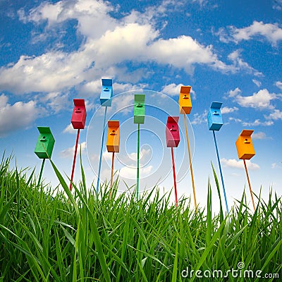 Nine colored bird houses on long stems in the sky background Stock Photo