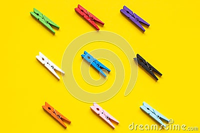 Nine colored clothespins on a yellow background Stock Photo
