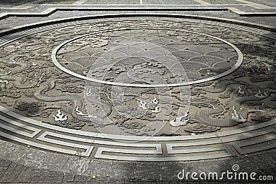 Nine dragons round stone carving on pavement Stock Photo