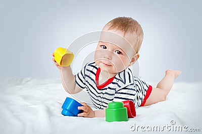 Nine month old baby lying in the bed on white blanket Stock Photo