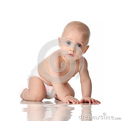 Nine month old infant baby boy with blue eyes wearing diaper crawling Stock Photo