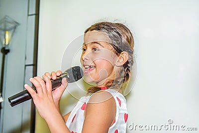 Nine year old girl singing with microphone Stock Photo