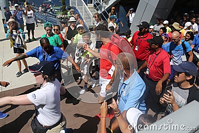 Nineteen times Grand Slam Champion Roger Federer of Switzerland walking toward Grandstand stadium surrounded by tennis fans Editorial Stock Photo