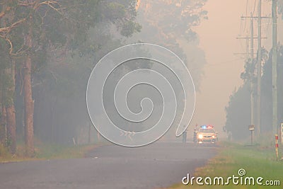 NINGI, AUSTRALIA - NOVEMBER 9 : Police holding cordon in front of bush fire front as it approaches houses November 9, 2013 in Editorial Stock Photo