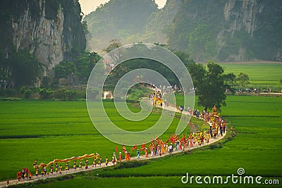 Ninh Binh, Vietnam - Apr 10, 2017: Thai Vi traditional spring festival with crowded people and palanquin, dancing dragon, flag...w Editorial Stock Photo