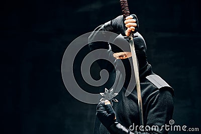 Ninja samurai warrior fighter with a sword and shuriken over black background Stock Photo