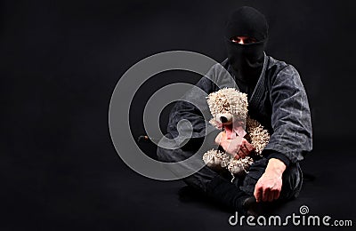 Ninja with teddy bear. Good and strength. Stock Photo