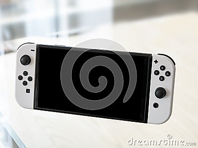 Nintendo Switch OLED Model in handheld mode. Popular mobile gaming console Editorial Stock Photo
