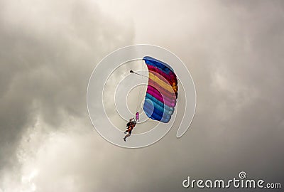 NIZHYN, UKRAINE - SEPTEMBER 17, 2016: Single skydiver On Colorful Parachute under cloudy rainy sky Editorial Stock Photo