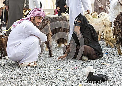 Omani couple at the Nizwa goat market with goats Editorial Stock Photo