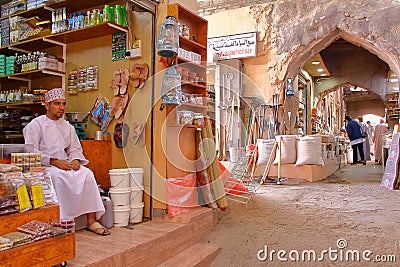 NIZWA, OMAN - FEBRUARY 2, 2012: The Souq in Nizwa Old Town with an Omani man traditionally dressed on the left Editorial Stock Photo