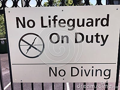No diving no lifeguard sign by an outdoor pool. Stock Photo