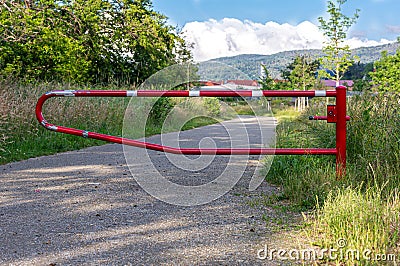 No entry. White and red barrier. Closed field road near the forest. Stock Photo