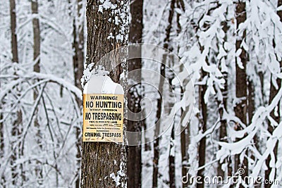 No hunting, no trespassing sign on a snowy tree in Wisconsin Stock Photo