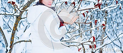 No name portrait of a charming girl who reads a book in the winter forest. Concept of Christmas, winter celebrations, walks in the Stock Photo