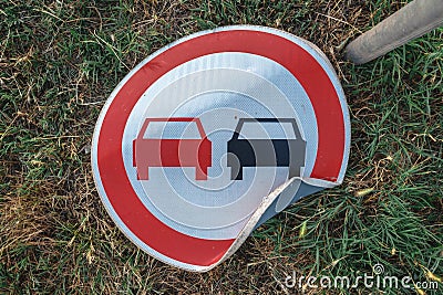 No overtaking traffic sign knocked on the ground Stock Photo