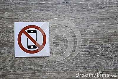 No phone allowed sign on the wooden wall with space for adding text on the right Stock Photo