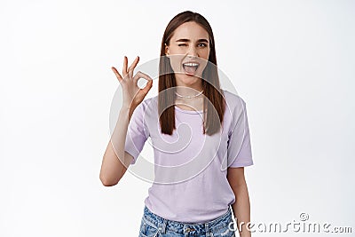 No problem. Beautiful girl winks at you with okay OK smile, understood everything, hinting, got all under control, say Stock Photo