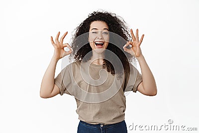 No problem. Smiling confident girl winking and showing OK okay gesture, approve something good, praise excellent choice Stock Photo