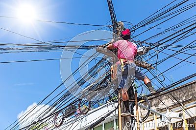 No safety worker technician installing Internet cables on the electricity poles Editorial Stock Photo