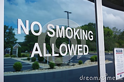 No smoking allowed letters on glass window Stock Photo