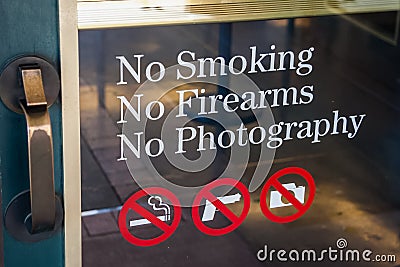No Smoking, No Firearms, No Photography sign at the door entrance Stock Photo