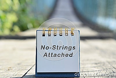 No strings attached text written on white note with blurred background of hanging bridge Stock Photo