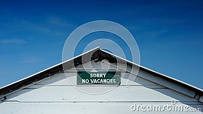 No vacancies sign set against deep blue sky Stock Photo