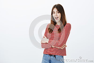 No way, are you telling truth. Amazed and surprised attractive caucasian female student in striped clothes, holding Stock Photo