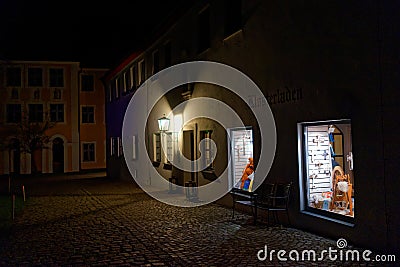 Deserted market place by lighted store windows night scene Editorial Stock Photo