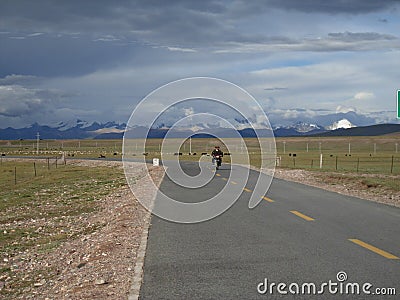 A nomads ride a motorcycle on the sky road in Tibet Editorial Stock Photo