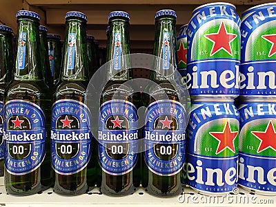 Non-alcoholic version of Heineken glass bottles and Aluminum can 0.0 beer on shelf in supermarket. Editorial Stock Photo