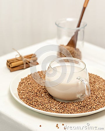 Cup of plant buckwheat milk with cinnamon sticks Stock Photo