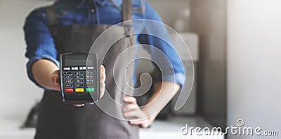 noncash payment - waitress with apron standing in cafe with pos terminal in hand Stock Photo
