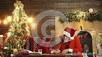 Nonno e nipotino preparano Natale o Capodanno all'albero di Natale Lettera di auguri per un bambino felice Wishlist a Babbo Natal