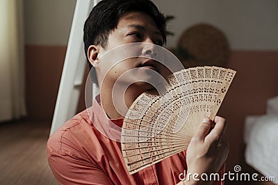 Nontraditional guy and his traditional fan Stock Photo