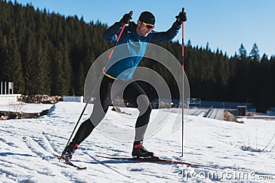 Nordic skiing or Cross-country skiing classic technique practiced by man in a beautiful panoramic trail at morning. Stock Photo