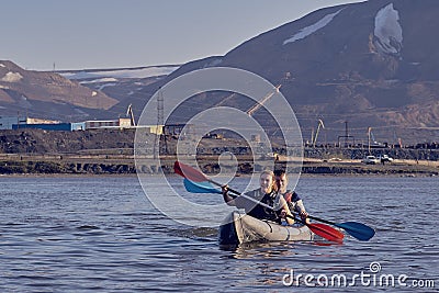 Norilsk, Russia - June 20, 2017: a guy and a girl floating on a kayak Editorial Stock Photo