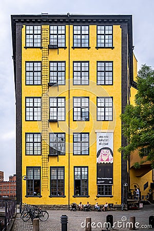 Front facade view of a famous old yellow industrial building. Museum Arbetets Hus with incidental people in Norrkoping Sweden Editorial Stock Photo