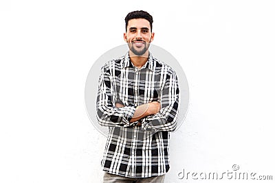 North African man smiling against white background with arms crossed Stock Photo