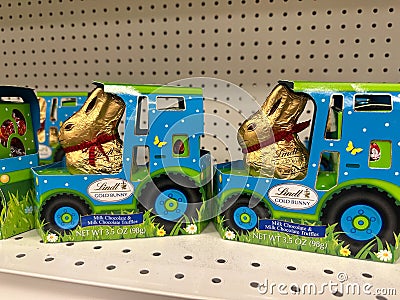 Packages of Lindt Gold Bunny milk chocolate easter candy, riding in a tractor Editorial Stock Photo